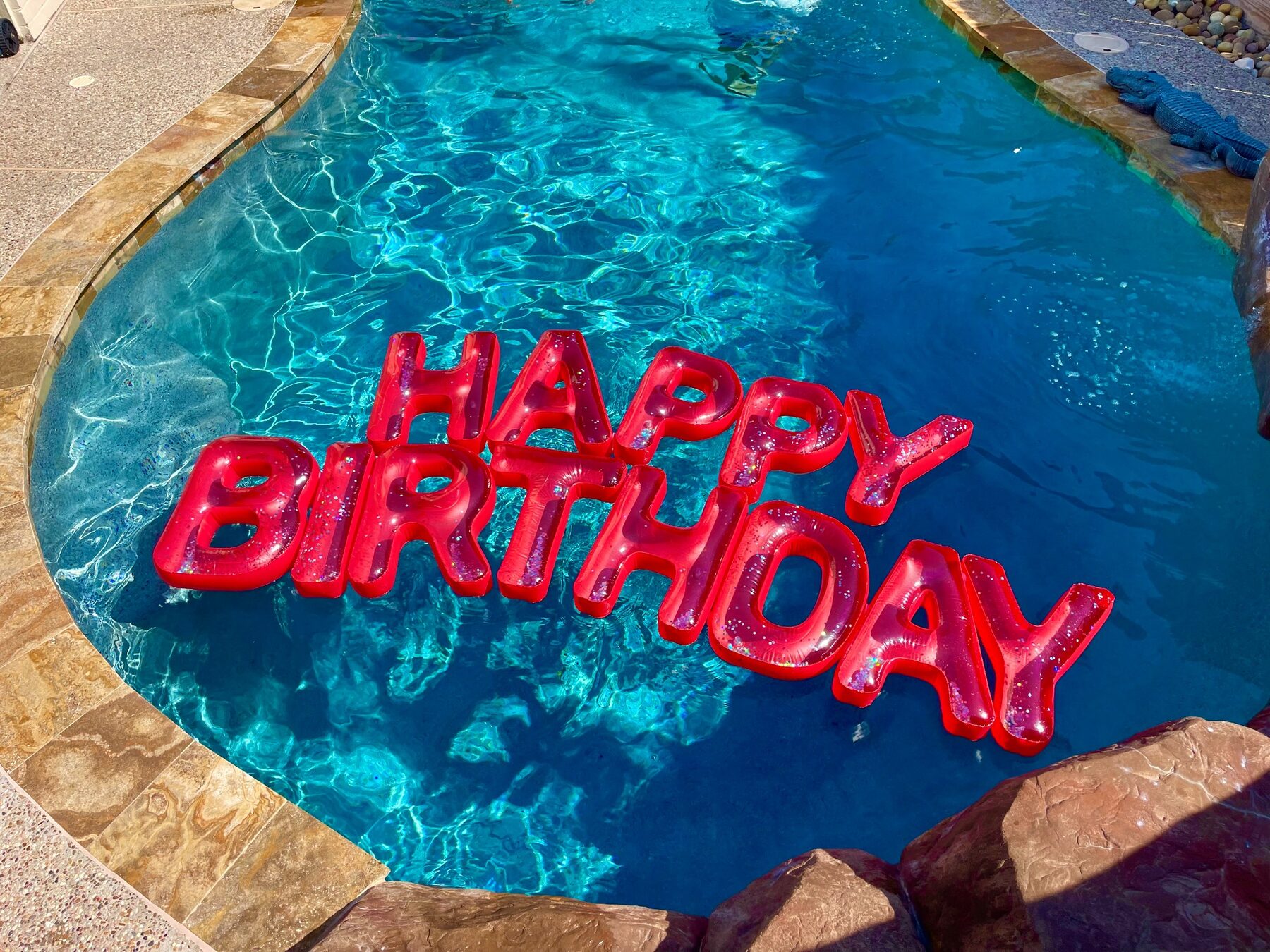 Large Happy Birthday floating letters in the pool