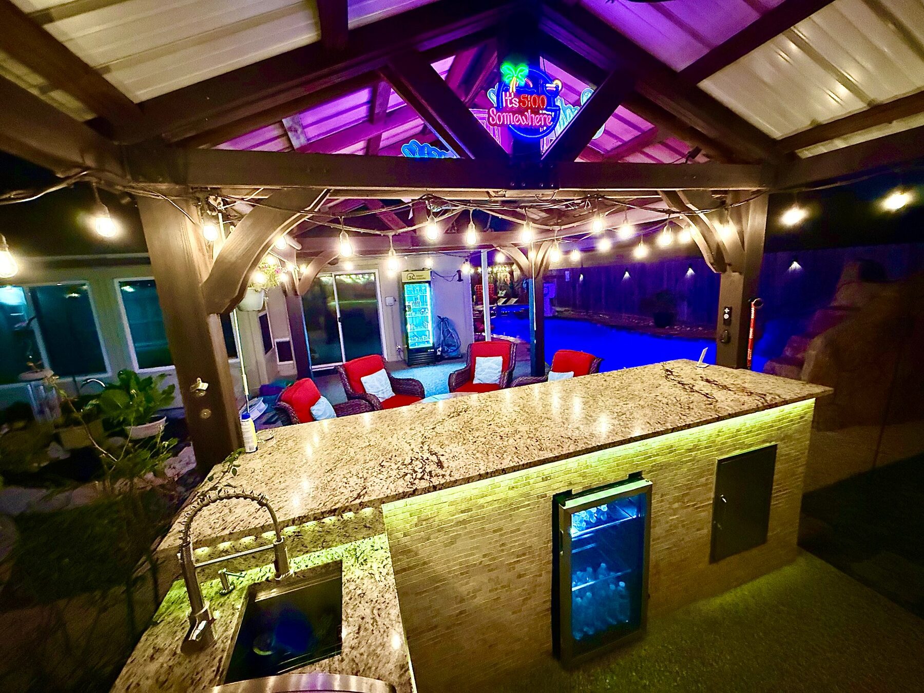 Granite serving bar glowing beneath the covered gazebo at night