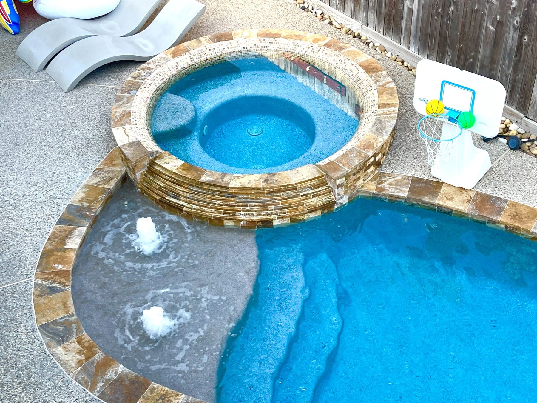 Raised custom hot tub beside the swimming pool