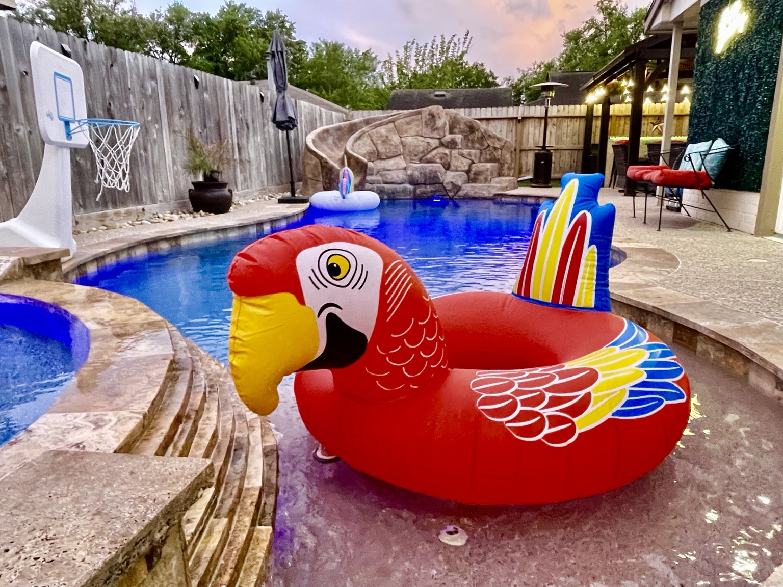 Parrot pool float with the pool and gazebo at twilight