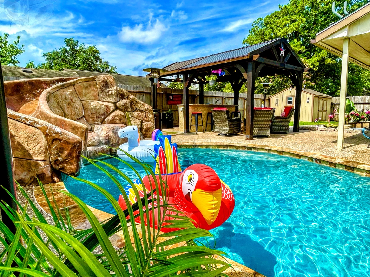 Rock waterslide, bright pool, floats and covered pavilion at Cypress River Oasis