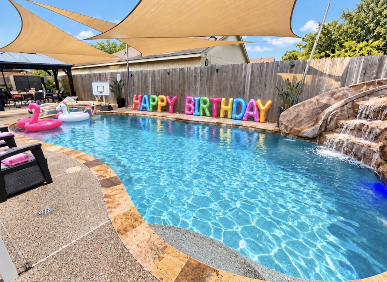 Cypress River Oasis pool with colorful HAPPY BIRTHDAY letters and rock waterslide